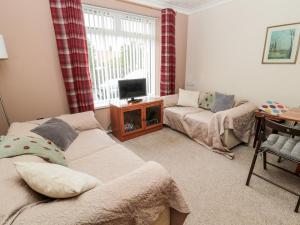 a living room with a couch and a tv at Golden Fleece Cottage in Berwick-Upon-Tweed