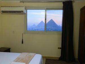 a bedroom with a window with a view of a mountain at Oscar pyramids view in Cairo