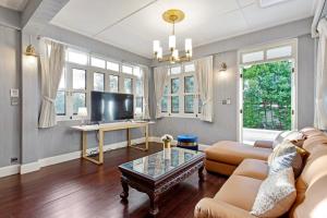 a living room with a couch and a table at Sathorn Private Pool Villa in Bangkok