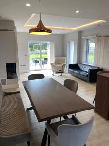 a living room with a wooden table and chairs at Emilys Garden 1 in Goleen