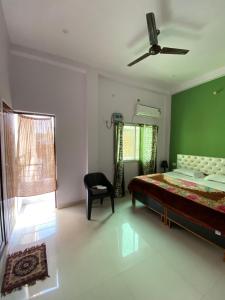 a bedroom with a bed and a green wall at Banaras Guest House in Varanasi