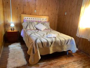 a bedroom with a bed with a white rug at Recantinho in Bom Jardim da Serra