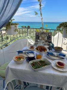 einen Tisch mit Nahrung und dem Meer im Hintergrund in der Unterkunft Dimora Mediterranea in Mattinata