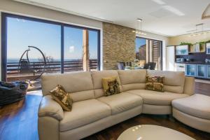 a living room with a couch and large windows at Holiday Home Villa Lion's House in Crikvenica