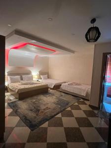 een slaapkamer met 2 bedden en een geruite vloer bij pyravista in ‘Ezbet `Abd el-Ḥamîd