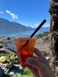 a person holding a drink with a straw at Casa Fedia in Gordola