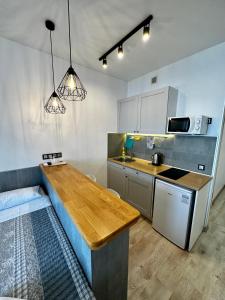 uma cozinha com um balcão de madeira num quarto em Panorama 44 em Odessa