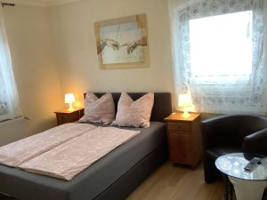 ein Schlafzimmer mit einem Bett mit zwei Lampen und einem Fenster in der Unterkunft Zimmer Wolkenlos in Dahme