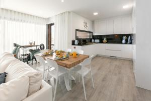 Una cocina y una sala de estar con mesa y sillas. en Consolação & Supertubos - Beach House II, en Atouguia da Baleia