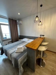 a bedroom with a bed with a wooden table and a desk at Panorama 44 in Odesa