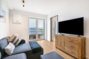 sala de estar con sofá y TV de pantalla plana en Snorrum Wohnung 7, en Husby