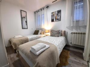 two beds in a room with white walls and windows at Aeropuerto - ifema - Wanda - Plenilunio in Madrid