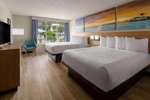 a hotel room with a bed and a television at Days Inn & Suites by Wyndham Fort Pierce Midtown in Fort Pierce +37 photos