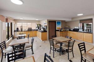 un restaurante con mesas y sillas y una cocina en Days Inn by Wyndham Oklahoma City, en Oklahoma City