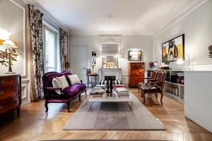 ein Wohnzimmer mit Tisch und Stühlen in der Unterkunft Veeve - Epic Romance in Neuilly-sur-Seine