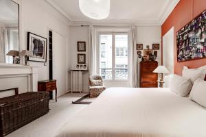 ein Schlafzimmer mit einem großen weißen Bett und einem Kamin in der Unterkunft Veeve - Epic Romance in Neuilly-sur-Seine