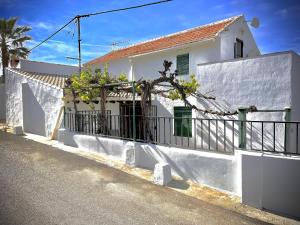 a white house with a fence on the side of a street at Casa Jasmin 