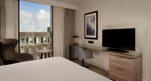 a hotel room with a bed and a desk with a television at Doubletree By Hilton Hull in Hull