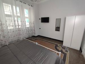 a bedroom with a bed and a tv and windows at Benny appartamento 3 CAMERE DA LETTO ad uso ESCLUSIVO Genova Aeroporto in Genoa