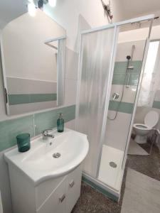 a white bathroom with a sink and a shower at Benny appartamento 3 CAMERE DA LETTO ad uso ESCLUSIVO Genova Aeroporto in Genova