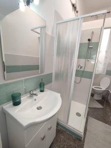 a white bathroom with a sink and a shower at Benny appartamento 3 CAMERE DA LETTO ad uso ESCLUSIVO Genova Aeroporto in Genoa