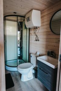 a bathroom with a shower and a toilet and a sink at Melamar in Smārde