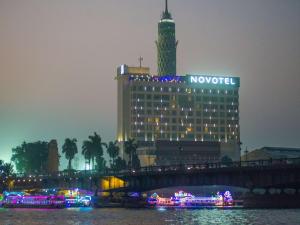 a large building with a clock tower on top of it at Hotel Novotel Cairo El Borg in Cairo