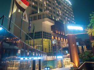 فندق نوفوتيل القاهرة البرج في القاهرة: مبنى كبير مع أعلام أمامه في الليل