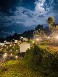 um grupo de luzes numa colina à noite em Nivriti Stays em Kanatal