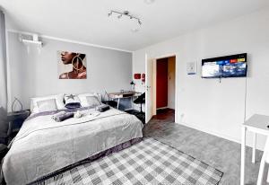 a bedroom with a bed and a desk and a television at # VAZ Apartments E02, Küche, WLAN, TV, Netflix, ca 15 Min Messe u HBf in Essen