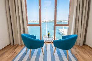 a dining room with a table and two blue chairs at Umag center seafront seaview old town apartment rentistra 1 in Umag