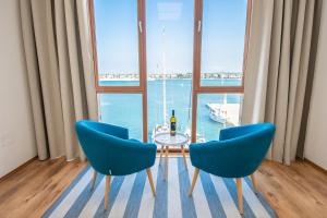 a dining room with a table and two blue chairs at Umag center seafront seaview old town apartment 1 in Umag