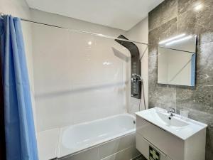 een badkamer met een wit bad en een wastafel bij Albufeira Central 7 by Homing in Albufeira