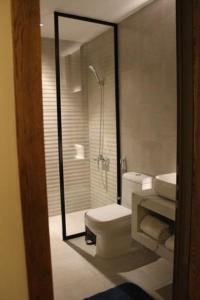 a bathroom with a toilet and a glass shower at Al Muhaidb Residence Jawazat in Riyadh