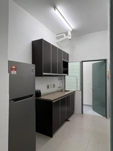 a kitchen with a stainless steel refrigerator and cabinets at 162 RESIDENCY SELAYANG in Batu Caves