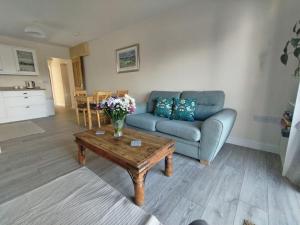 a living room with a couch and a coffee table at New spacious and sunny annexe with Underfloor heating throughout in Culmstock