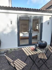 um pátio com comodidades para churrascos e um quarto com uma cama em New spacious and sunny annexe with Underfloor heating throughout em Culmstock