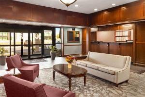 a living room with a couch and a table at Ramada Plaza by Wyndham Portland in Portland