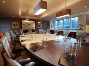 ein großer Konferenzraum mit einem großen Tisch und Stühlen in der Unterkunft Pullman Dubai Jumeirah Lakes Towers in Dubai