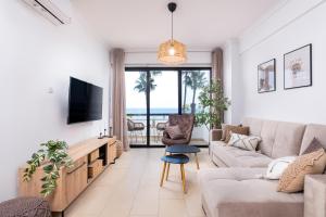 a living room with a couch and a tv at Quattro Beachfront Sea View Ap 206 in Larnaka