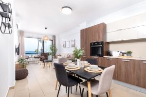 a kitchen and living room with a table and chairs at Quattro Beachfront Sea View Ap 206 in Larnaka