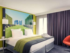 - une chambre avec un grand lit orné d'une peinture murale dans l'établissement Mercure Paris Ouest Saint Germain, à Saint-Germain-en-Laye