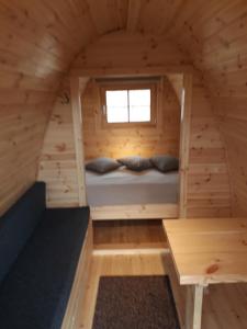 a room in a log cabin with a bed and a window at Fossatun Camping Pods & Cottages - Sleeping Bag Accommodation in Fossatún