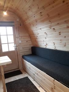a room with a bench in a wooden wall at Fossatun Camping Pods & Cottages - Sleeping Bag Accommodation in Fossatún