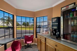 a restaurant with a bar with a table and chairs at Econo Lodge in Cornersville