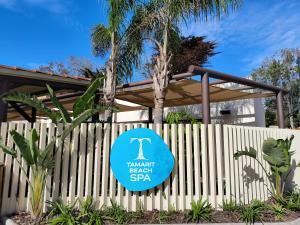 a sign for the embassy beach resort spa on a fence at Tamarit Beach Resort in Tamarit