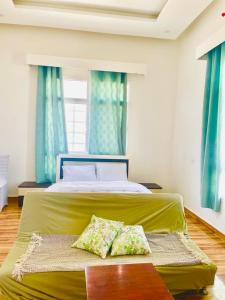 a bedroom with a green bed with two pillows on it at Atlas Wadi Shab in Sur
