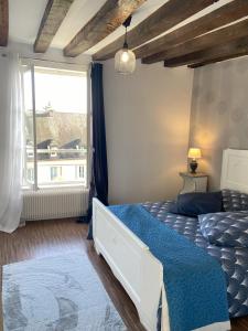 une chambre avec un lit bleu et une fenêtre dans l'établissement L'Ecuyère-Maison de Ville-Secteur cathédrale-Parking privé gratuit, à Chartres