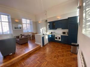 a kitchen with blue cabinets and a living room at Crowcombe Court in Crowcombe