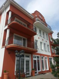 a red and white building with balconies at Villa Osowianka in Gdańsk
